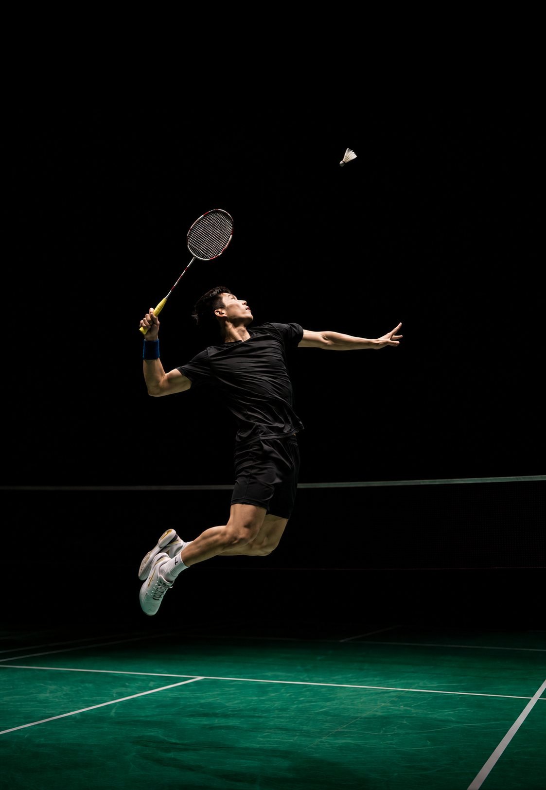A badminton player in mid-air, about to smash